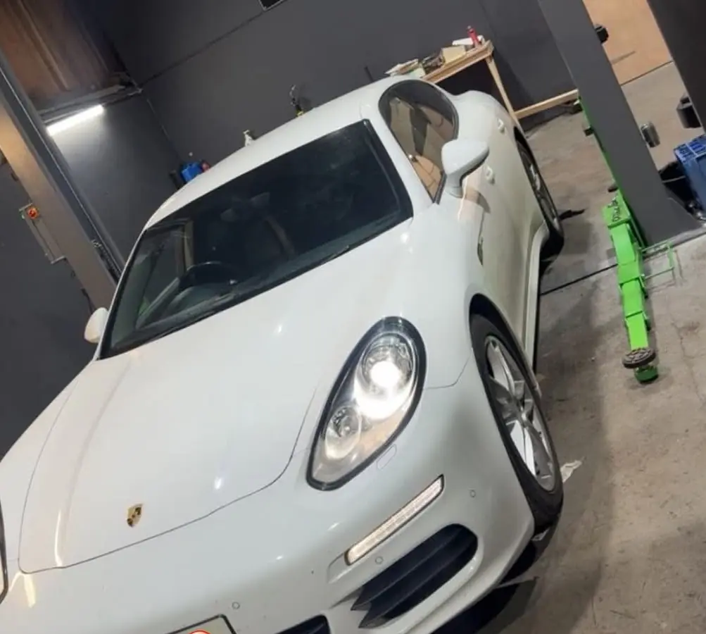 Windscreen and side glass of a white Porsche Panamera in the Auto Lab workshop